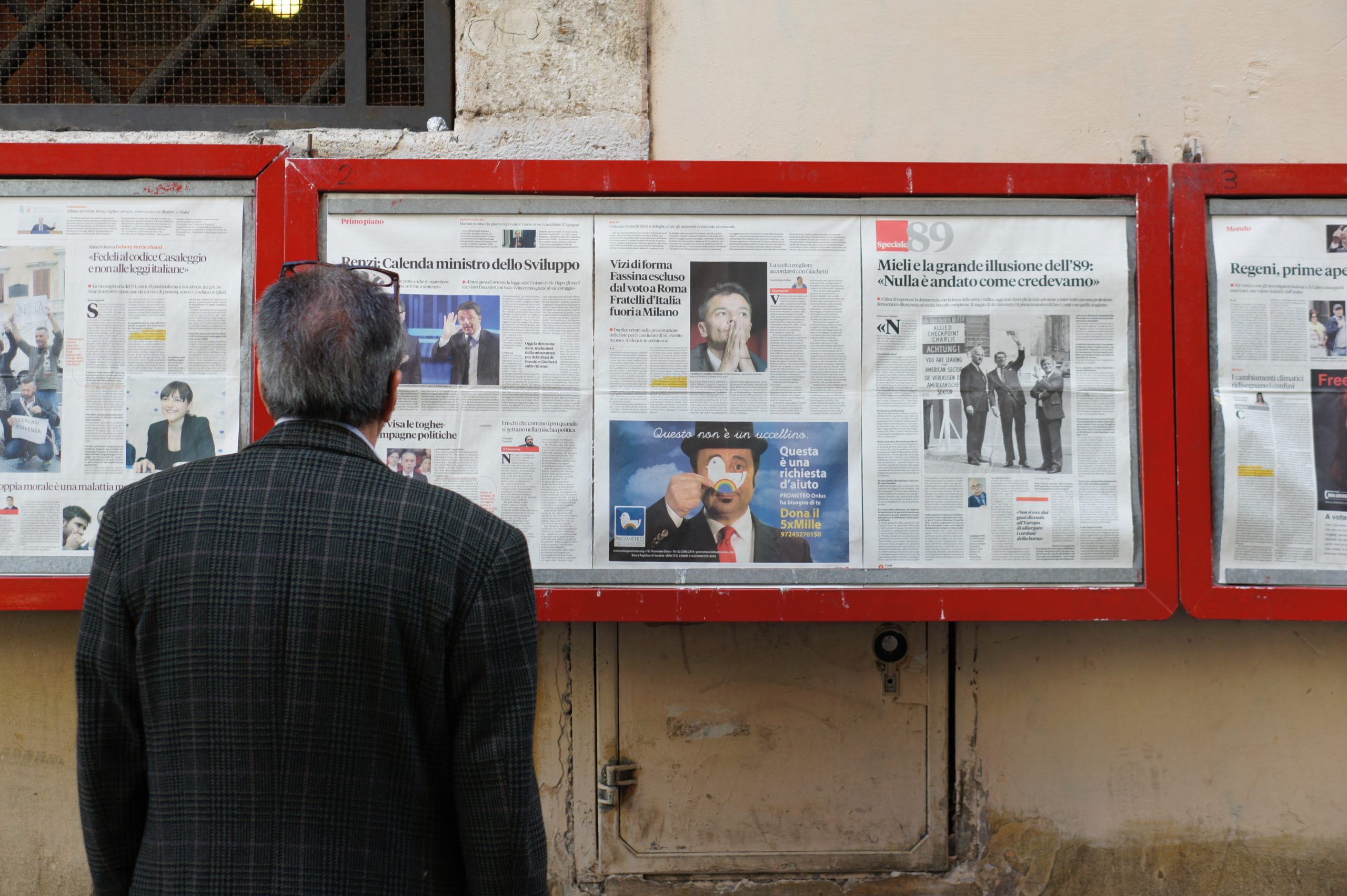 A man in front of many newspapers