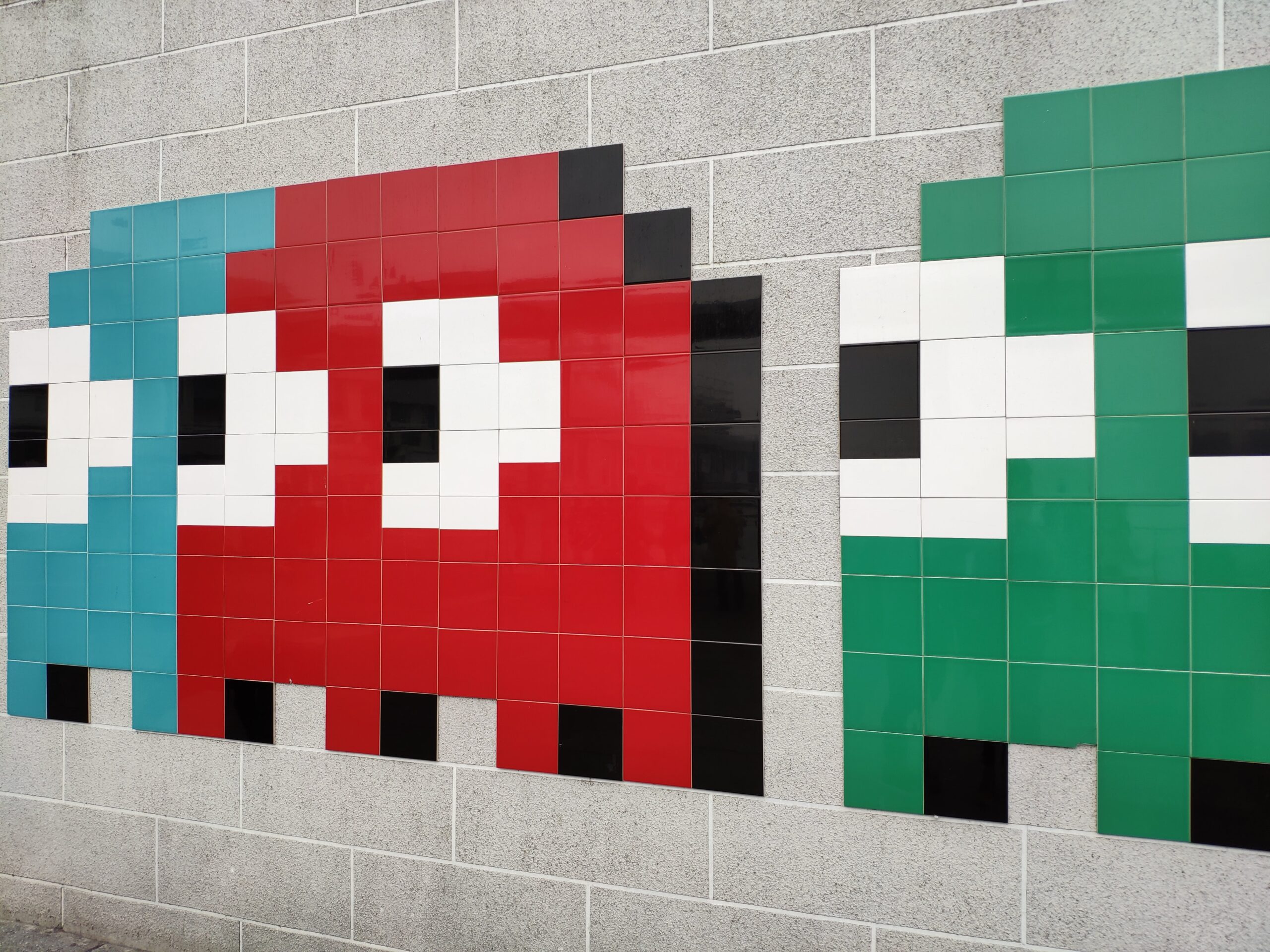 This image shows a wall full of Pac-Man ghosts, part of a videogame.