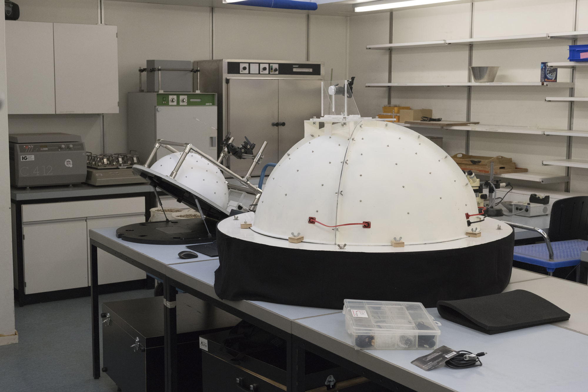 A laboratory with a big table and two RTI domes on top, which look like a big and a small pizza oven.