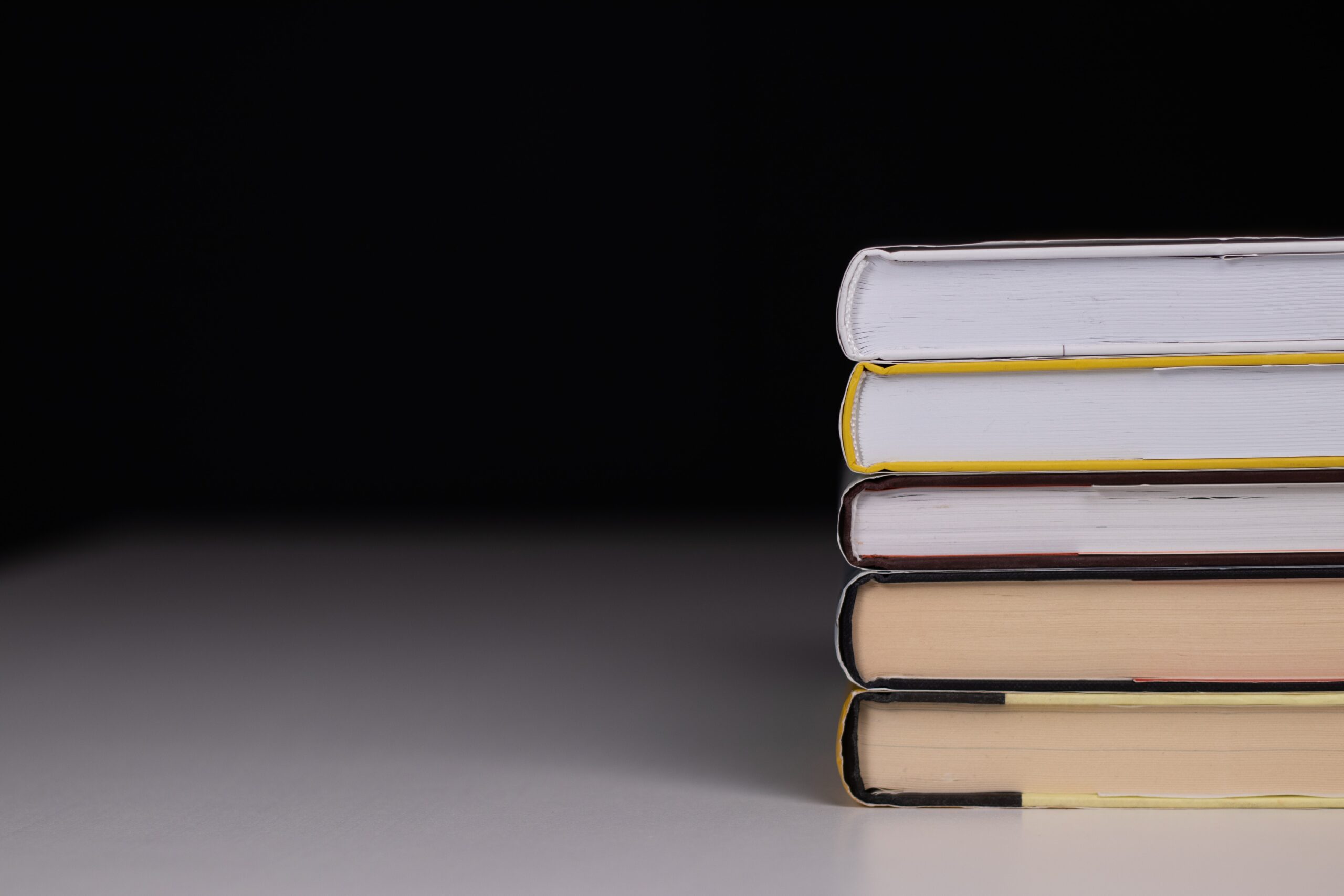 A pile of five books on the table. Photo by dlxmedia.hu on Unsplash