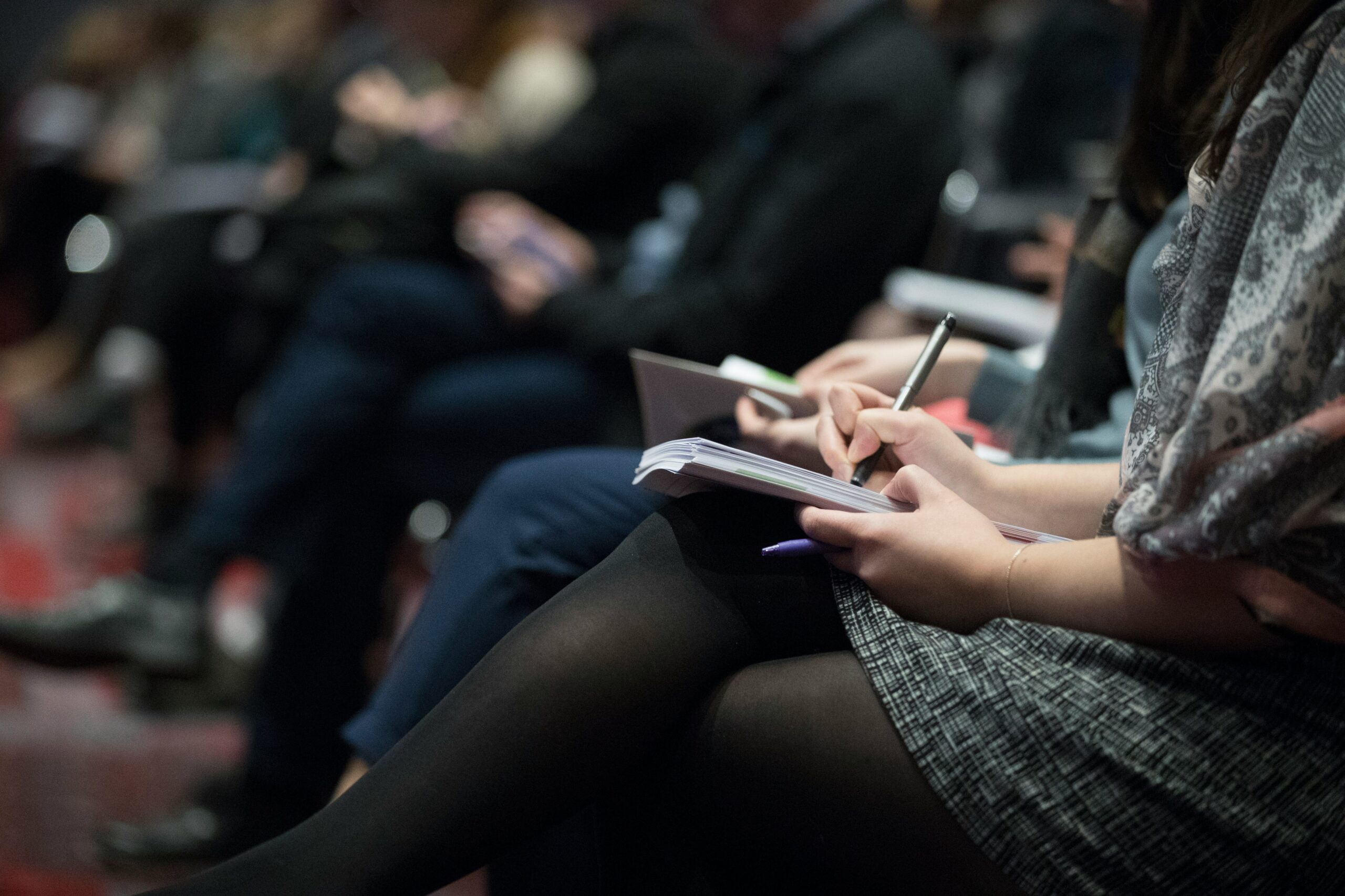 Legs of sitting people noting things down. © Photo by The Climate Reality Project on Unsplash